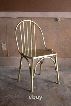 Chaise de salle à manger en métal avec dossier Windsor doré, finition laiton ancien moderne et polie.