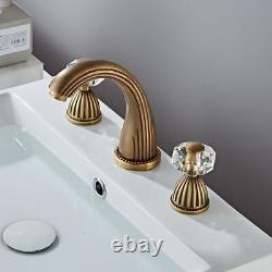 Robinet de lavabo à large bassin en laiton plaqué or avec poignée en cristal et bec verseur.